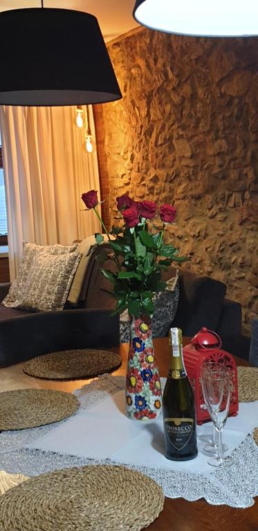 uma mesa com um vaso com rosas e uma garrafa de vinho em W sercu Srebrnej Góry em Srebrna Góra