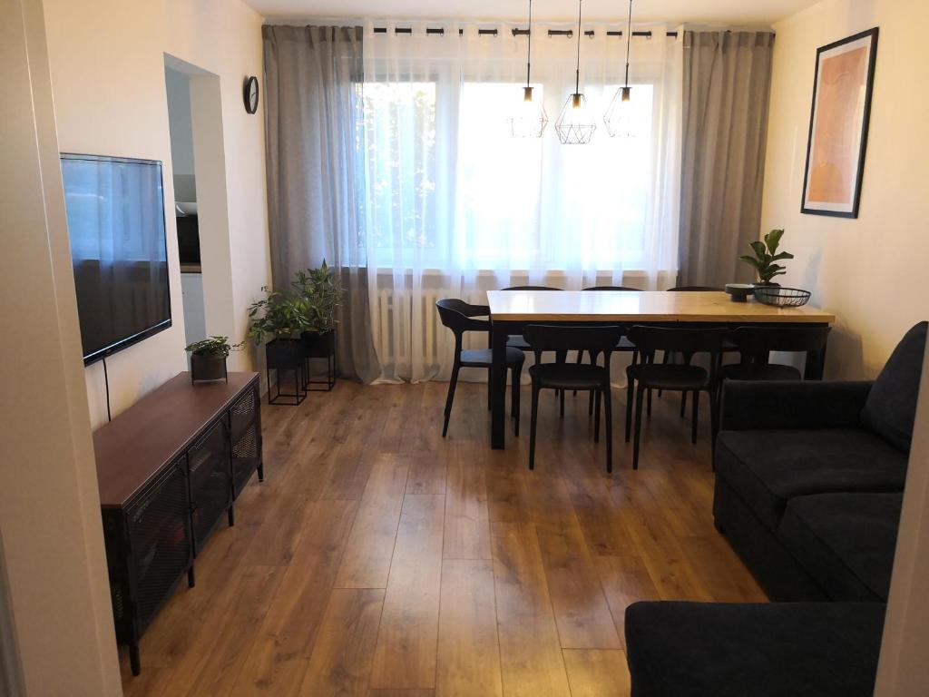 ein Wohnzimmer und ein Esszimmer mit einem Tisch und einem TV in der Unterkunft Apartament przy Starówce in Sandomierz