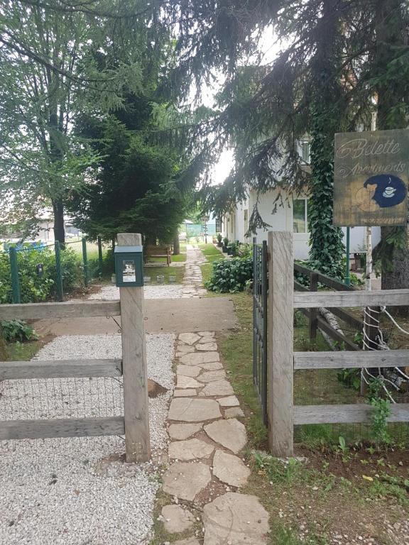 einen Holzzaun und ein Tor vor einem Haus in der Unterkunft Belette Apartments & Park in Nikšić