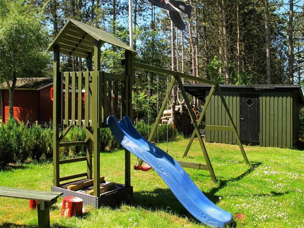 a playground with a blue slide and a swing at 8 person holiday home in R dby in Rødby