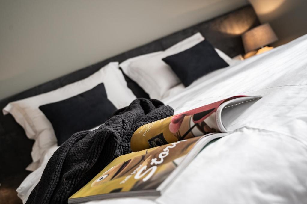 a bed with white sheets and black pillows at Villa Jasmine in Bolzano