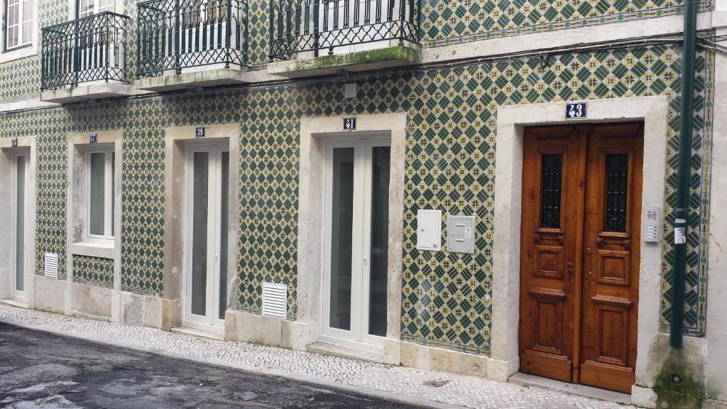 a building with green and white tiles and a wooden door at Rossio Suites in Lisbon