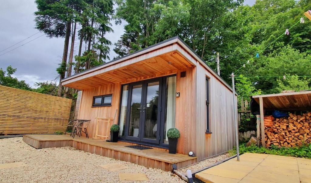 a tiny house with a porch and a fence at Portree Garden Room in Portree