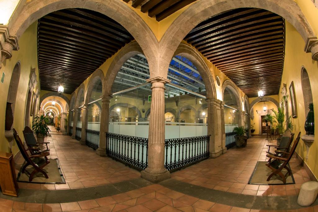 an empty hallway in a building with arched ceilings at Hotel Los Juaninos in Morelia