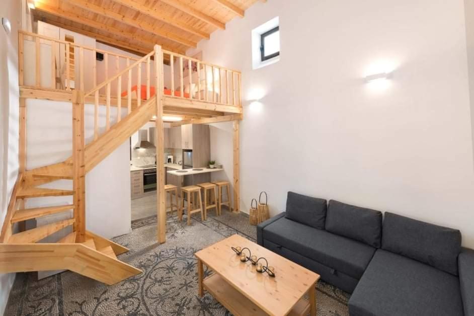 - un salon avec un canapé et un escalier en bois dans l'établissement Niochori apartments 1, à Rhodes