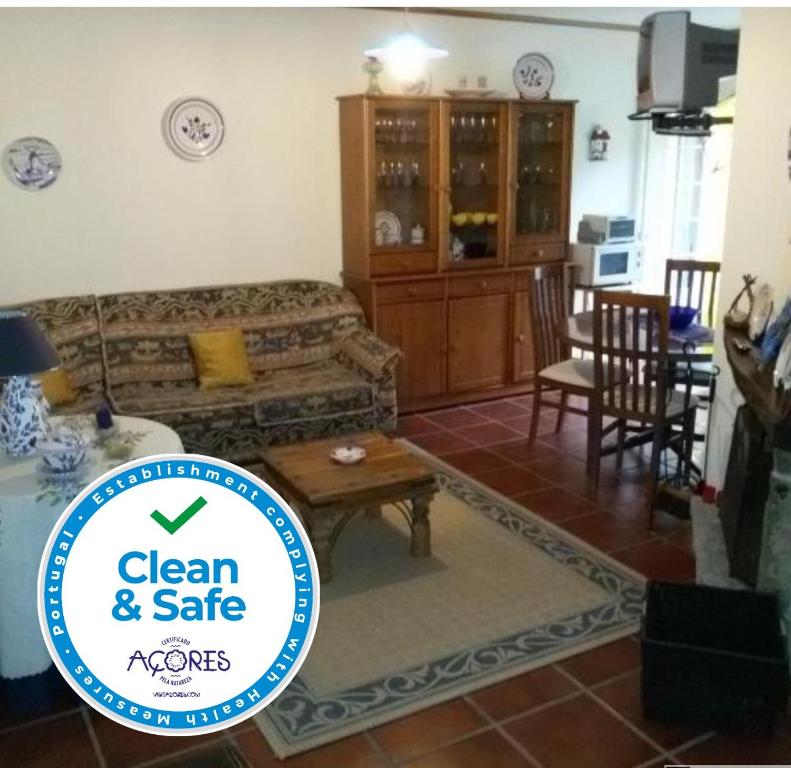 een woonkamer met een bank en een tafel bij Casa da Beija - House Azores in Furnas