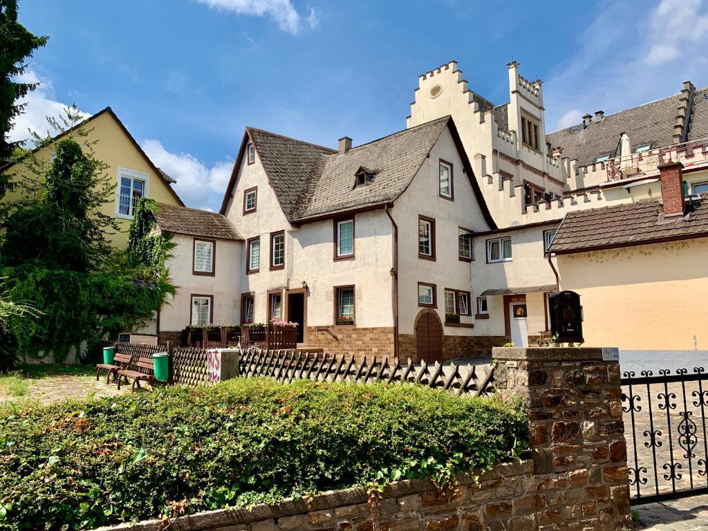 uma grande casa branca com uma cerca em frente em Fewo Am Brunnen em Rüdesheim am Rhein