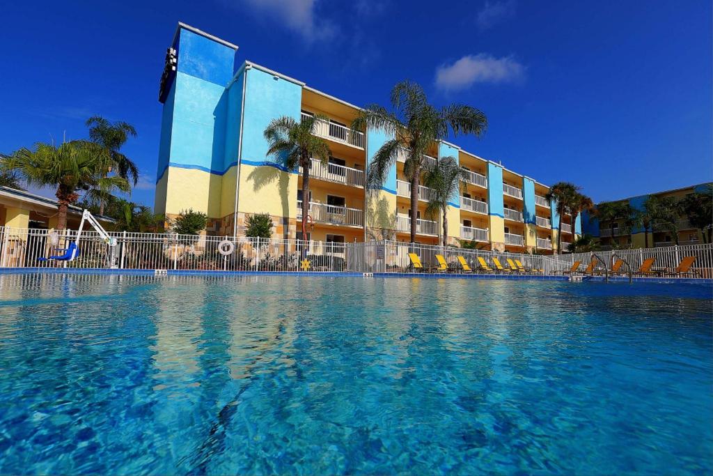 a hotel room with a swimming pool and a blue sky at SureStay Plus by Best Western Orlando International Drive in Orlando