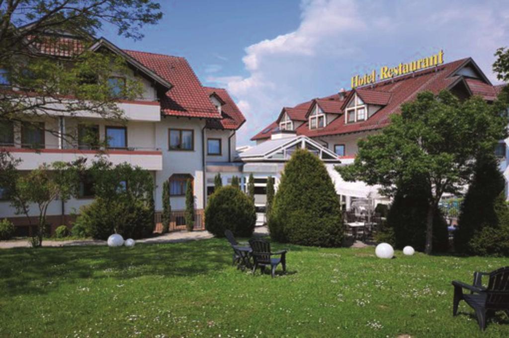 un groupe de bancs dans l'herbe devant un bâtiment dans l'établissement Hotel Empfinger Hof, Sure Hotel Collection by Best Western, à Empfingen