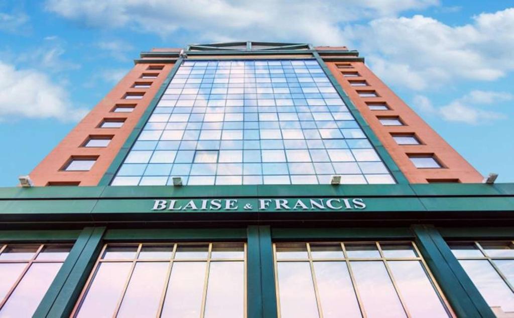 ミラノにあるHotel Blaise & Francisの看板が上がる高層ビル