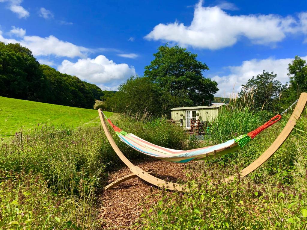 a hammock on the side of a field at Mid Wales Luxury Huts in Darowen