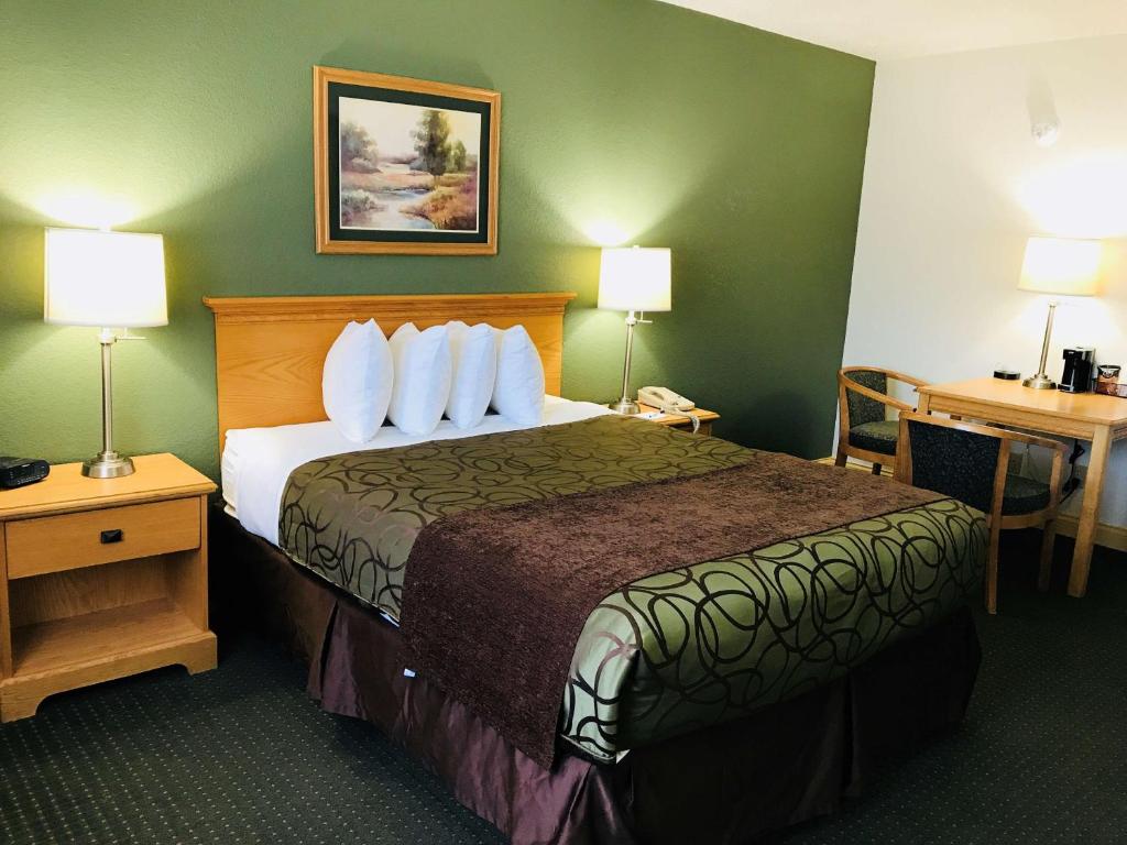 a hotel room with a large bed and a desk at Baymont by Wyndham Robinson in Robinson