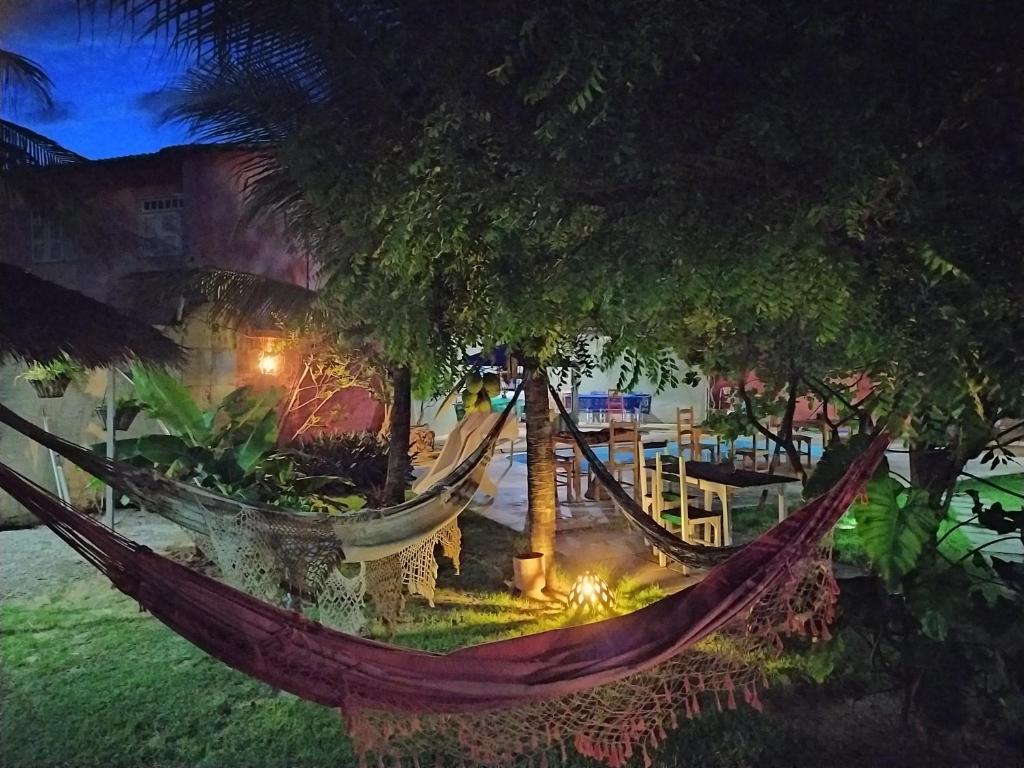 a hammock in a garden with trees at night at Pousada A Vida é Bela in Águas Belas