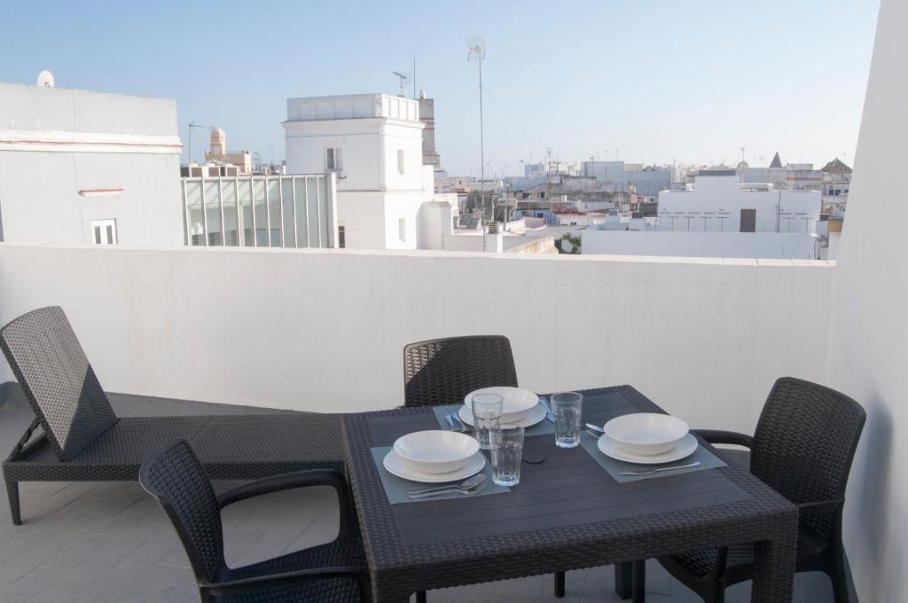 a black table and chairs on a balcony with a view at El mirador de Ancha in Cádiz