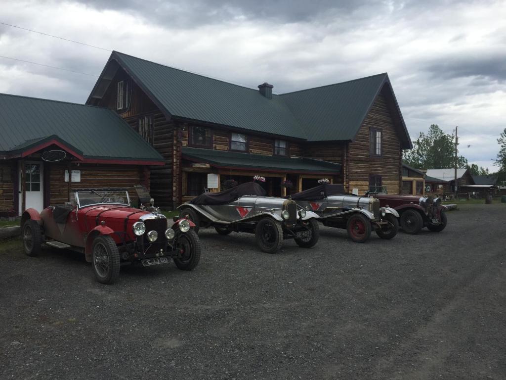 een groep antieke auto's geparkeerd voor een blokhut bij Gakona Lodge in Gakona