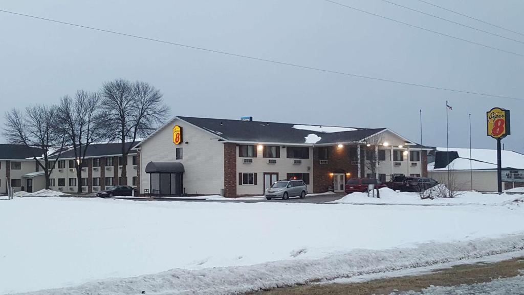a snow covered street with a building with a parking lot at Super 8 by Wyndham Plover Stevens Point Area in Plover