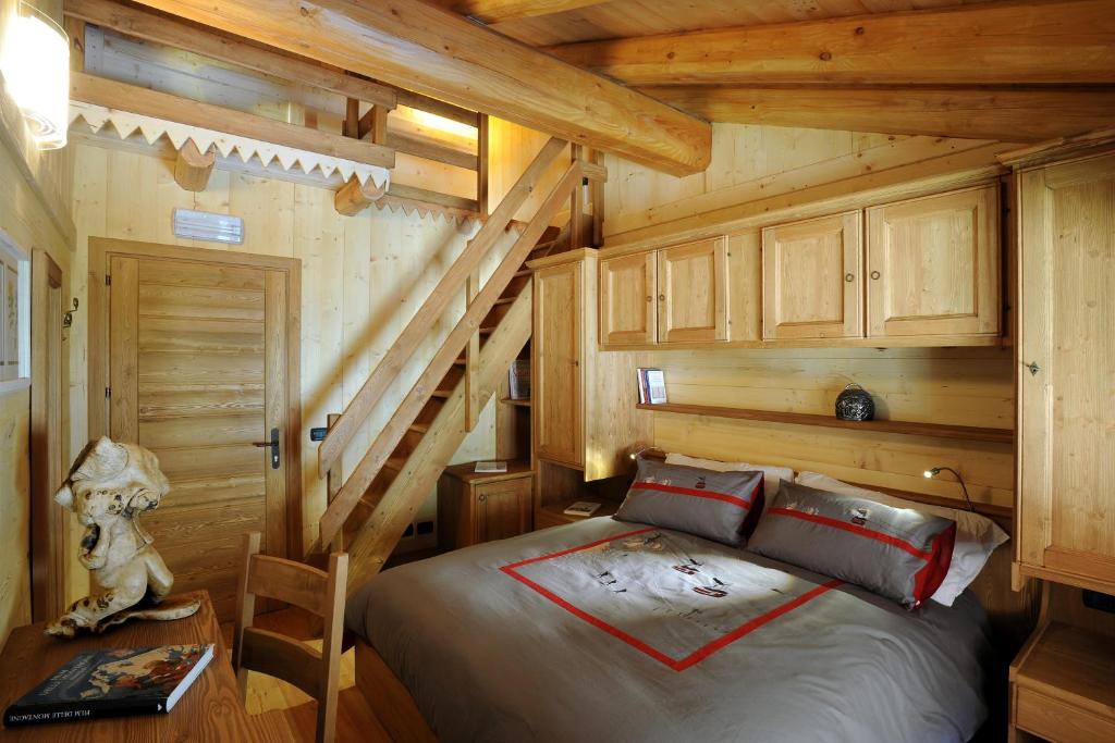 una camera con un letto in una baita di tronchi di HIBOU chambres & spa - Cogne a Cogne