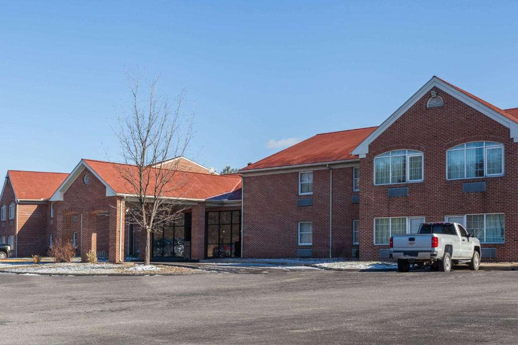 um edifício de tijolos com um camião estacionado em frente em Days Inn & Suites by Wyndham Lancaster Amish Country em Lancaster