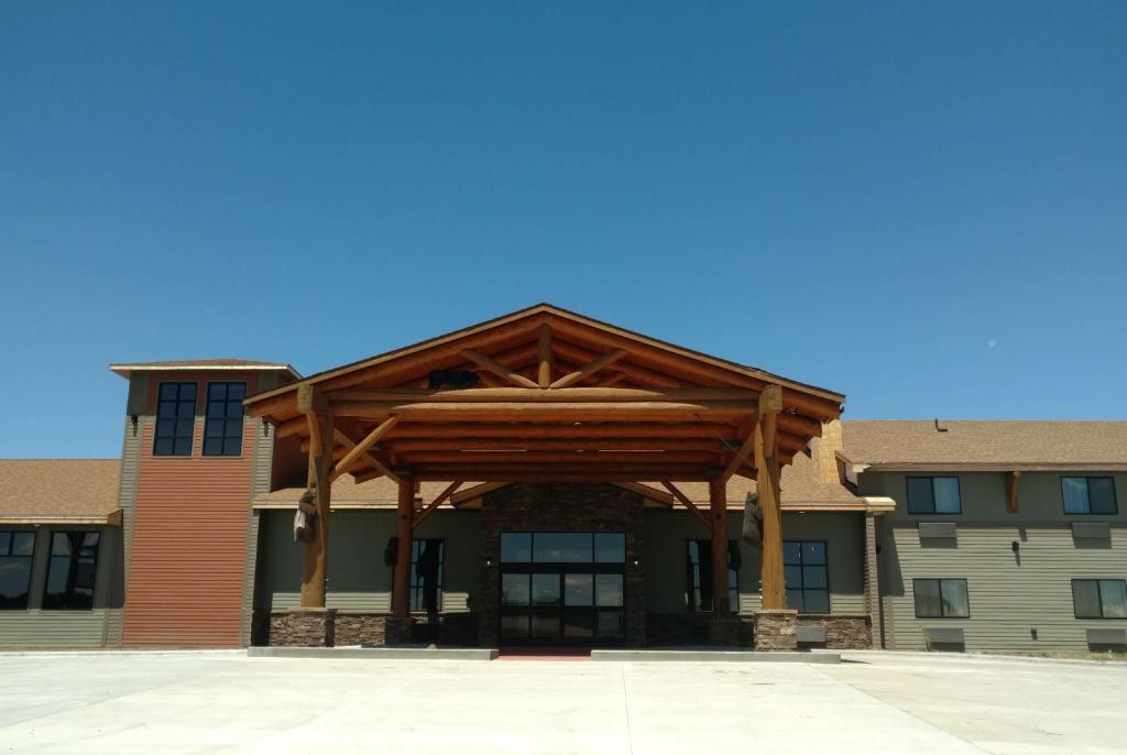 ein großes Gebäude mit einer Holzverkleidung auf der Vorderseite in der Unterkunft Baymont by Wyndham Oacoma in Oacoma