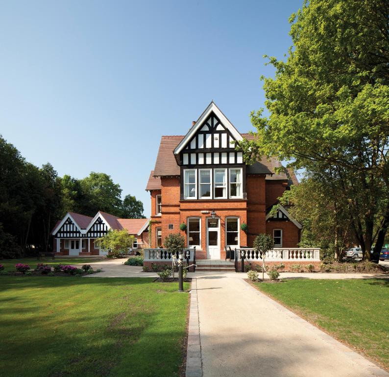 una gran casa de ladrillo con una acera delante de ella en The Dower House Hotel en Woodhall Spa