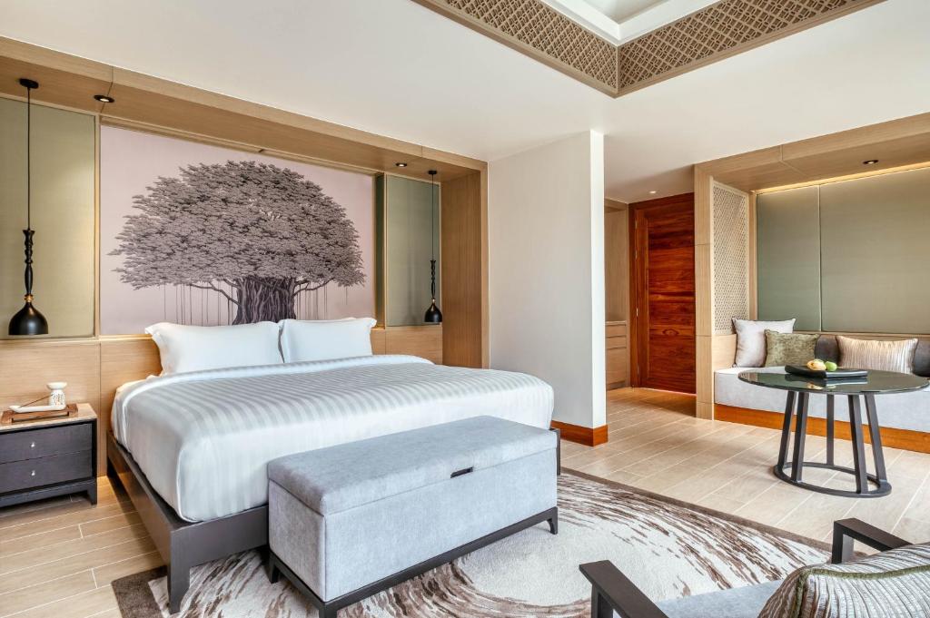 a bedroom with a bed and a living room at Banyan Tree Phuket in Bang Tao Beach