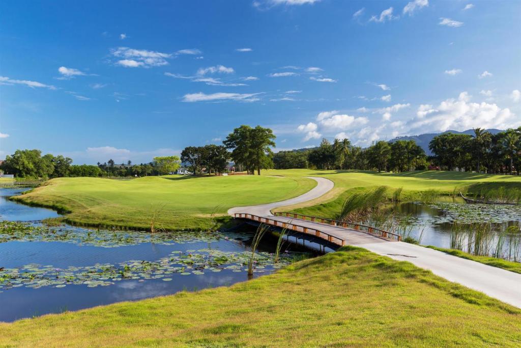a golf course with a bridge over a river at Banyan Tree Phuket in Bang Tao Beach