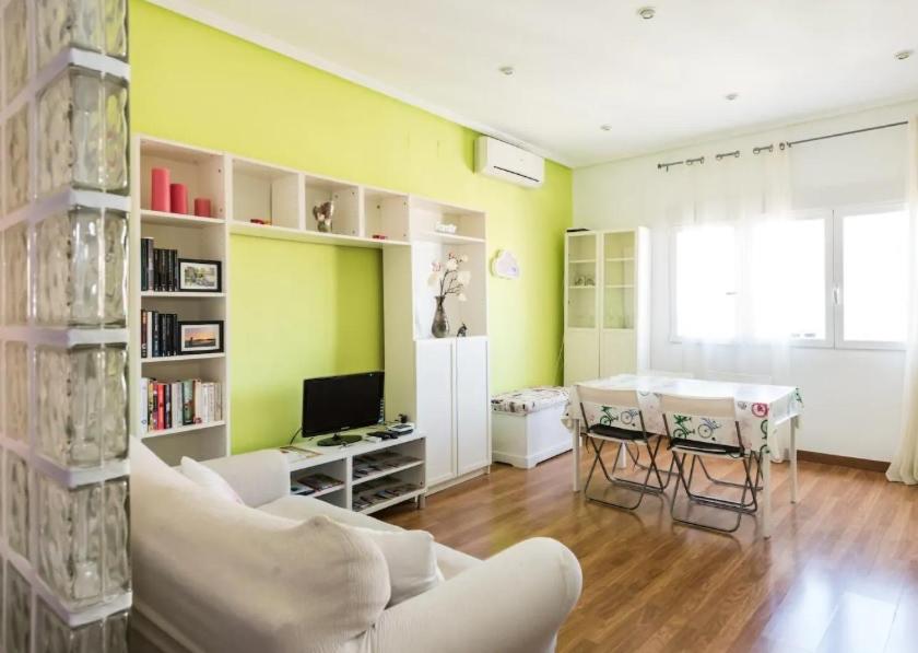 een woonkamer met een witte bank en een tafel bij Puerta del Sol Apartament in Madrid