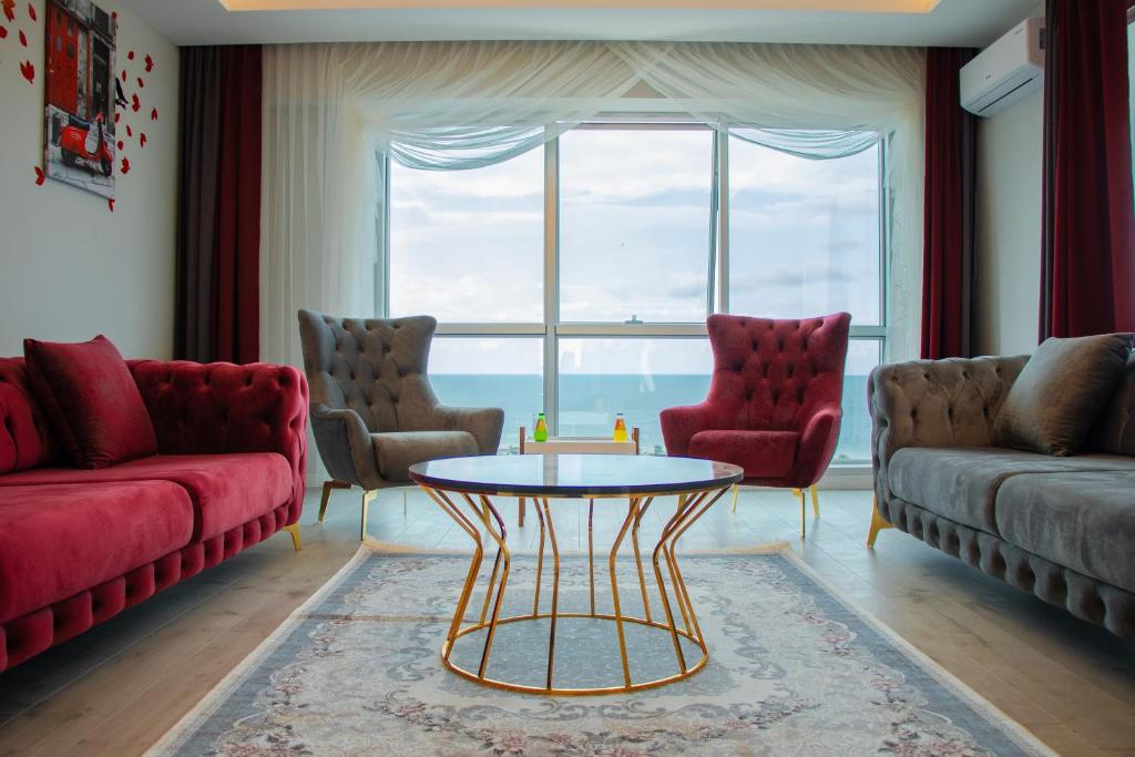 a living room with red furniture and a large window at ELEGANT BLUE SUİTES in Trabzon