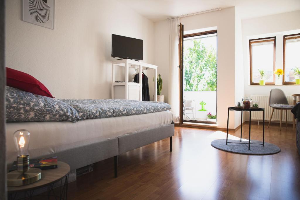 ☆ Gemütliches Apartment in der Nähe von Stuttgart في فايبلينغن: غرفة نوم بسرير وتلفزيون على الحائط
