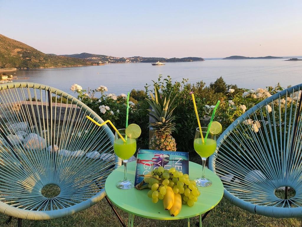 a table with two chairs with drinks and fruit on it at Apartments A&M in Mlini