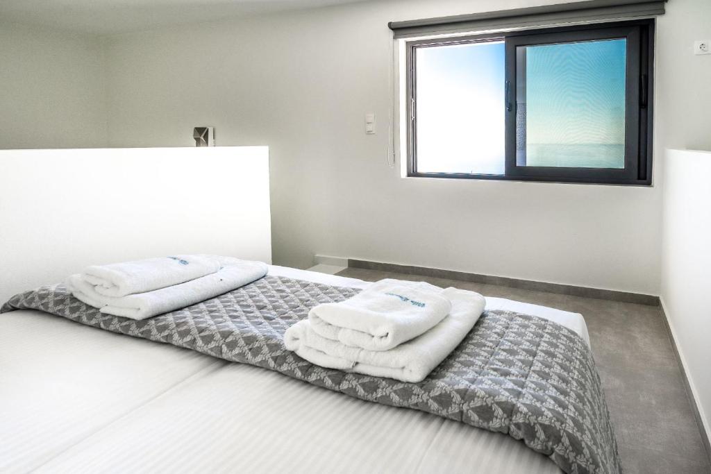 sypialnia z łóżkiem z ręcznikami w obiekcie Villa Daniela & Apartments w mieście Koutsounari