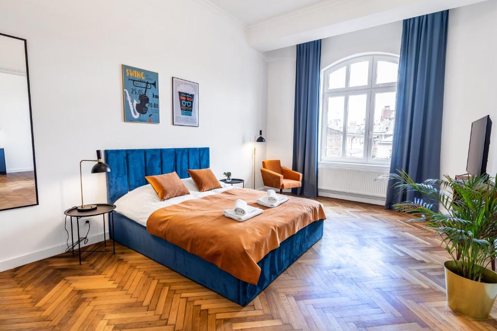 a bedroom with a king sized bed with blue curtains at 2BCOMFY - Barlickiego in Bielsko-Biała