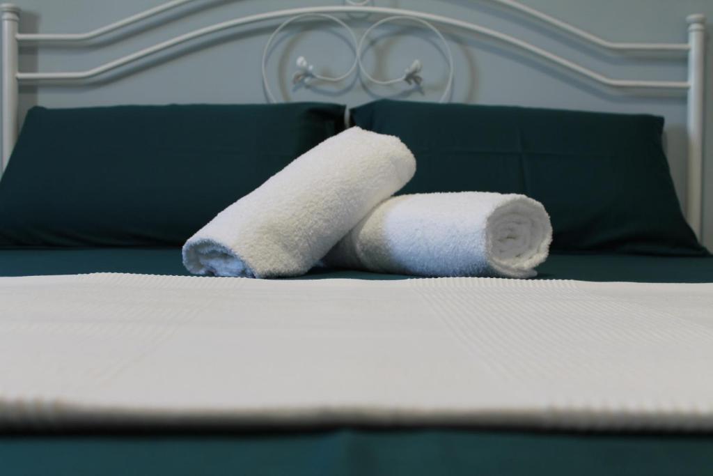 dois rolos de toalhas sentados em cima de uma cama em Il giardino di Artemide em Corato