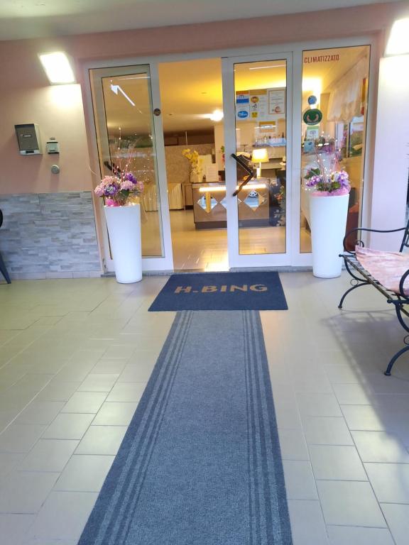un vestíbulo con una alfombra de bienvenida frente a una tienda en Hotel Bing, en Rímini