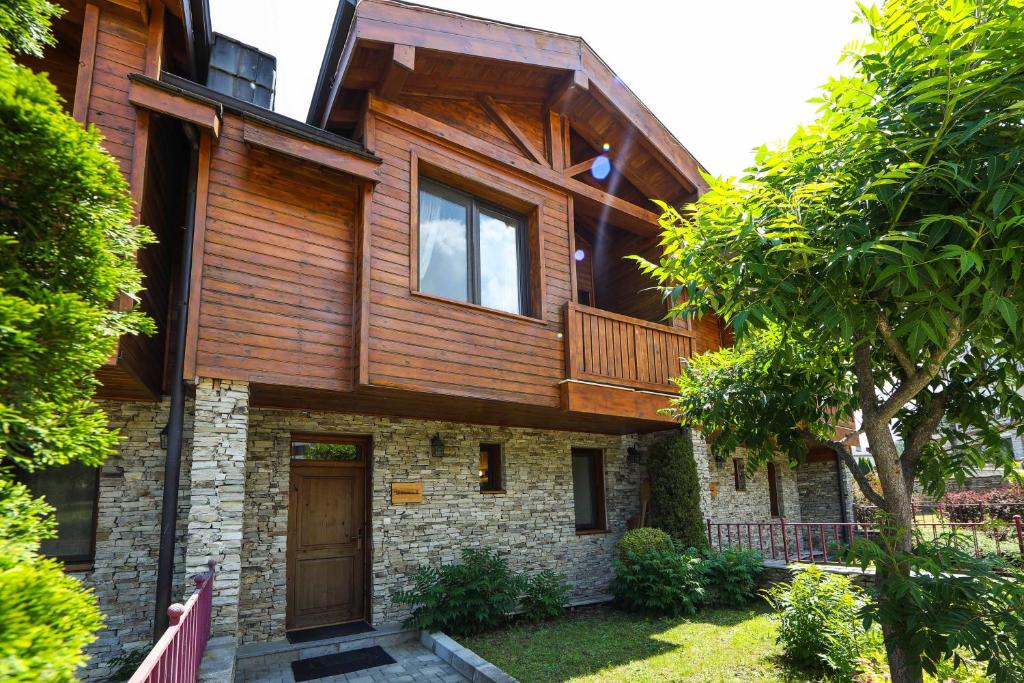 a wooden house with a balcony on top of it at Lake View House in Bansko