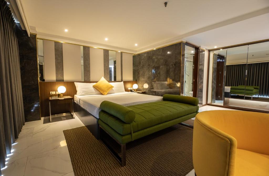 una camera d'albergo con letto e divano verde di Star Plaza Hotel a Dagupan