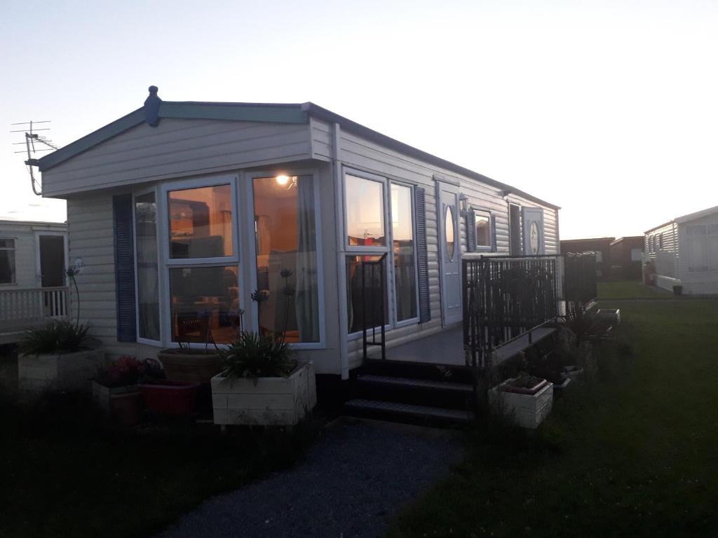 a small house with glass doors and a porch at Mablethorpe L17 Caravan in Mablethorpe