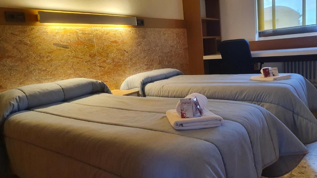 a hotel room with two beds with towels on them at Albergue Peregrinos San Francisco de Asis in León