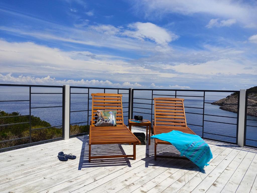 zwei Stühle auf einer Terrasse mit Blick auf das Wasser in der Unterkunft Living Point Mobile Homes in Mali Lošinj