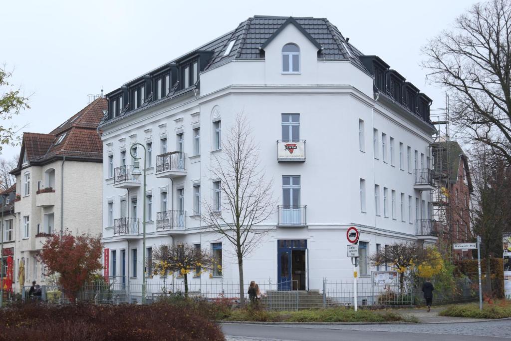 un gran edificio blanco con techo negro en Jugendgästehaus des CVJM Berlin-Kaulsdorf en Berlín