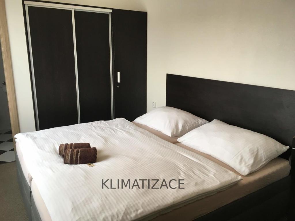Una cama con una cabecera negra y una bolsa marrón. en Hotel Jordánek, en Opočno
