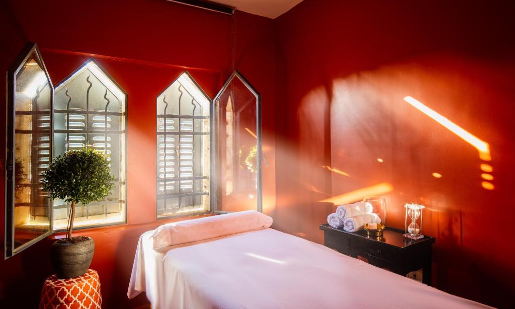 a red bedroom with a bed and two windows at Villa Brown Moshava - a member of Brown Hotels in Jerusalem