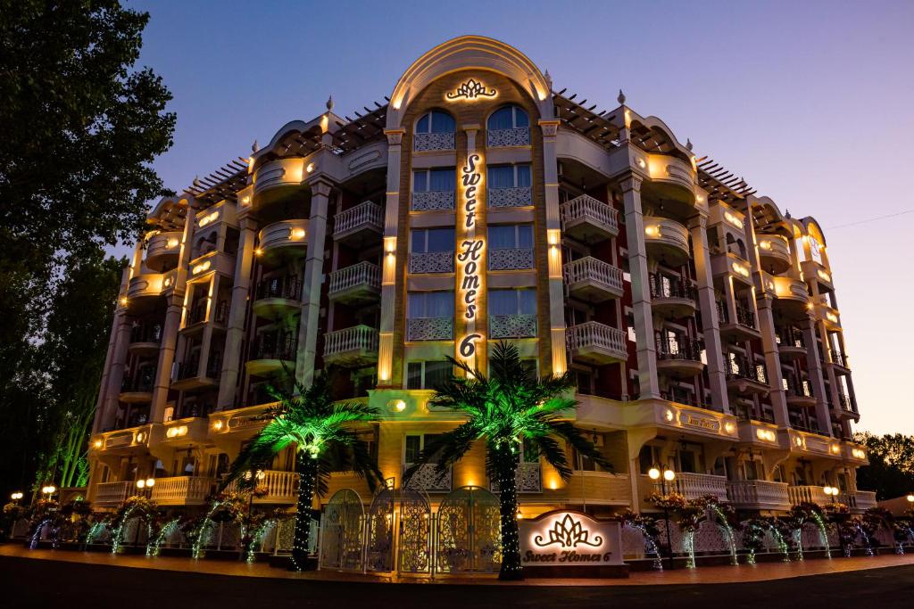 a large building with palm trees in front of it at Sweet Homes 6 Apartments in Sunny Beach