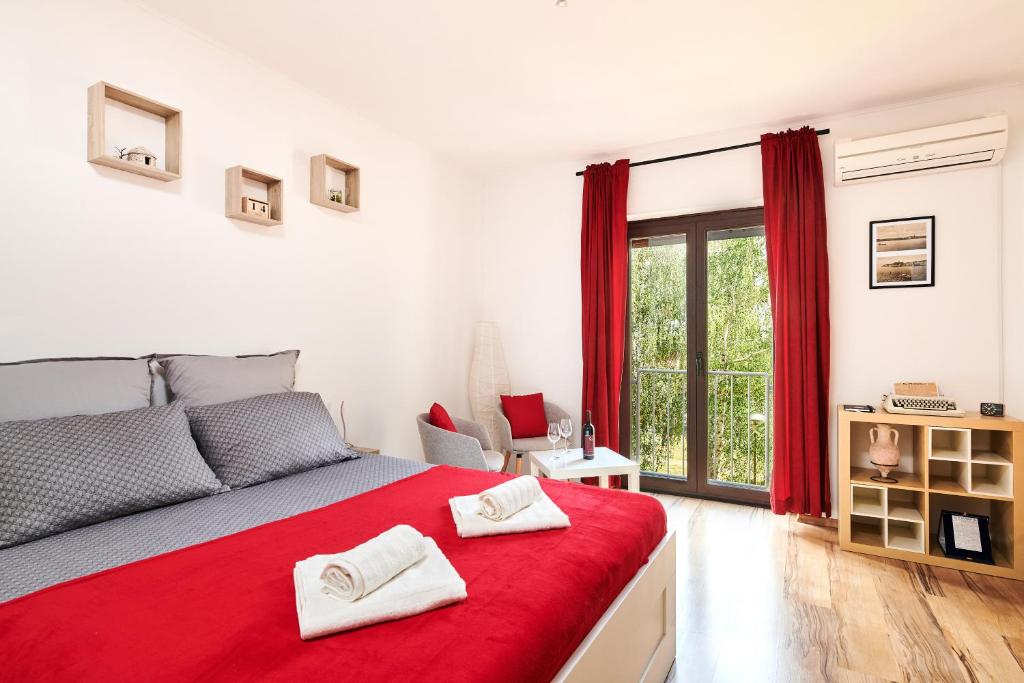 a bedroom with a red bed with two white towels at Apartment Piccolo in Umag
