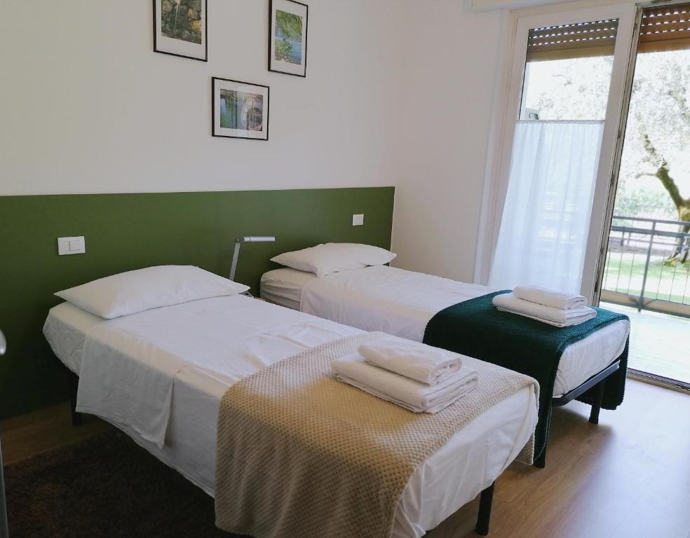 2 Betten in einem Zimmer mit Fenster in der Unterkunft Olive Tree House in Riva del Garda