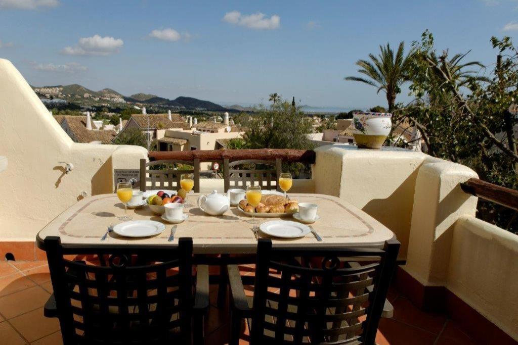 una mesa con comida y bebida en el balcón en La Manga Club Resort - El Rancho 357, en Atamaría