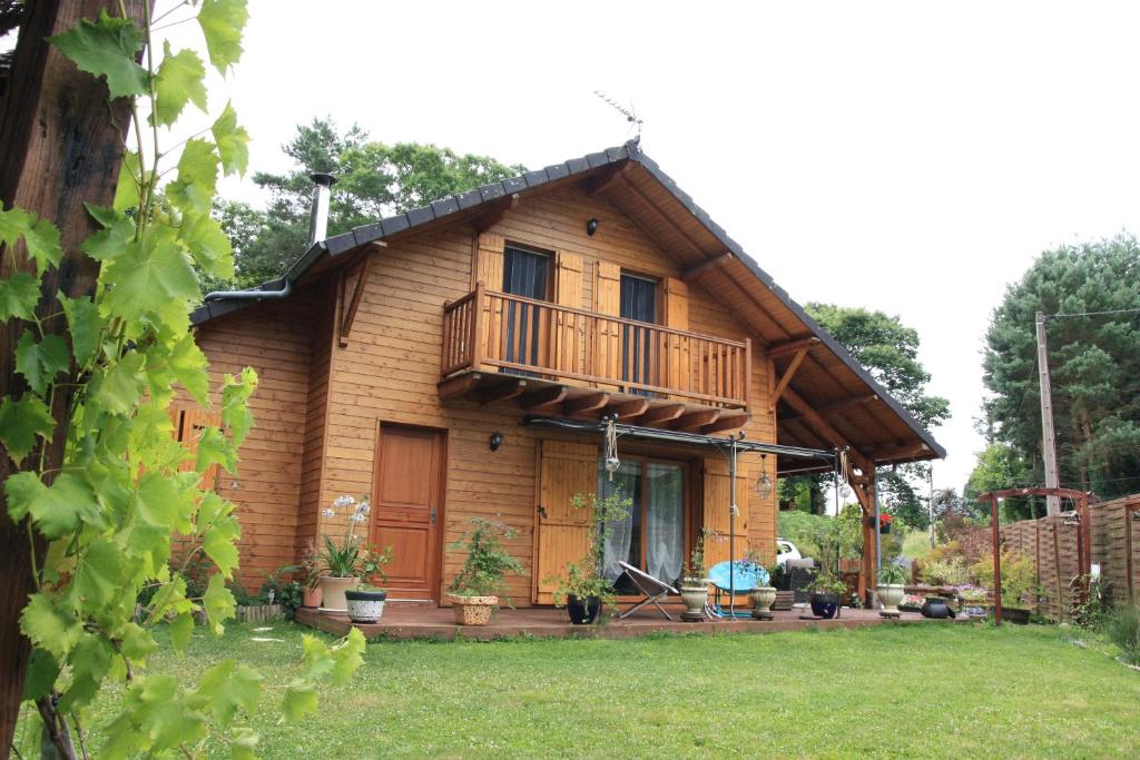 Cette maison en bois dispose d'un balcon et d'une cour. dans l'établissement leschambresdanne, à Chameyrat