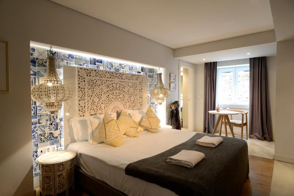 1 dormitorio con 1 cama grande con almohadas amarillas en Dalma Old Town Suites, en Lisboa