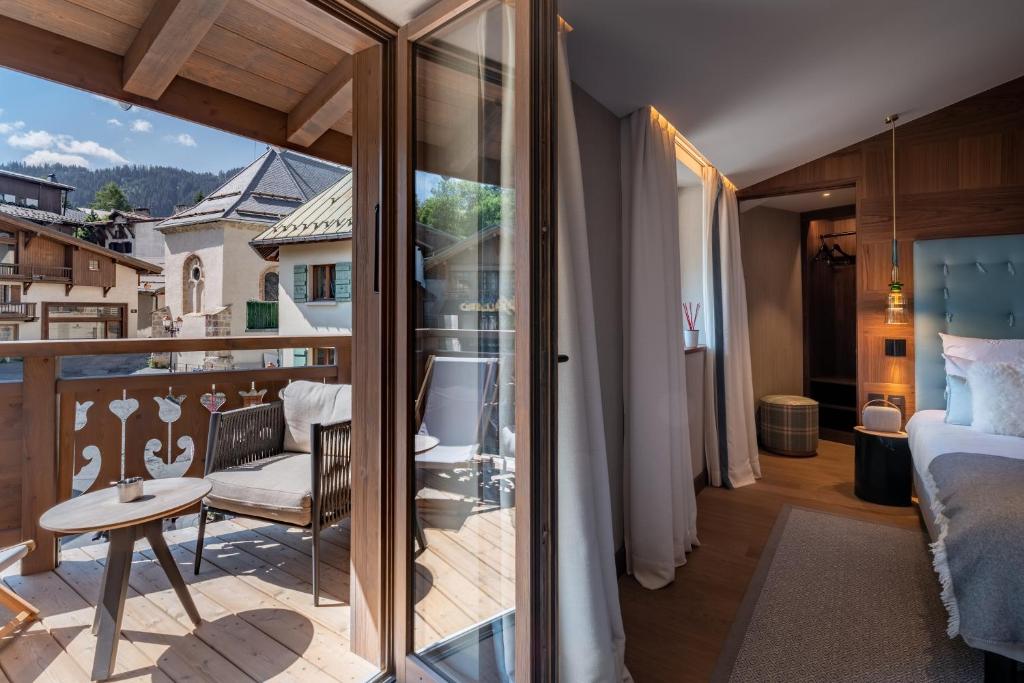 a room with a balcony with a view of a bedroom at Coeur de Megève in Megève