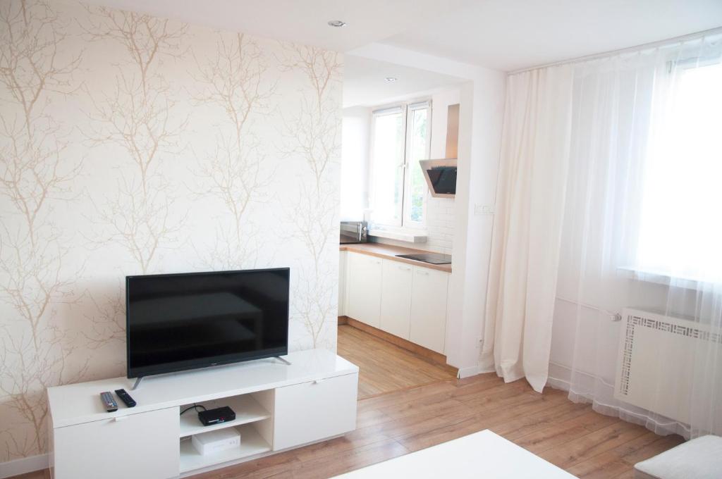 una sala de estar con TV en un armario blanco en Apartament Jawa, en Łódź